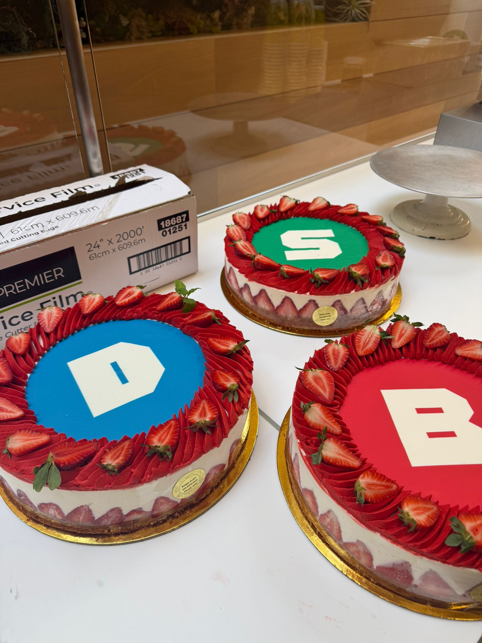 Fresh custom logo cakes on a partner bakery's counter, ready to go out