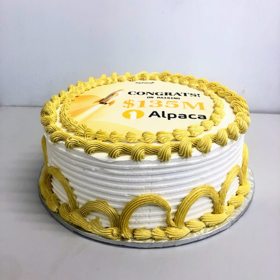 A cake with yellow piping printed with Congrats on raising $135M, Alpaca