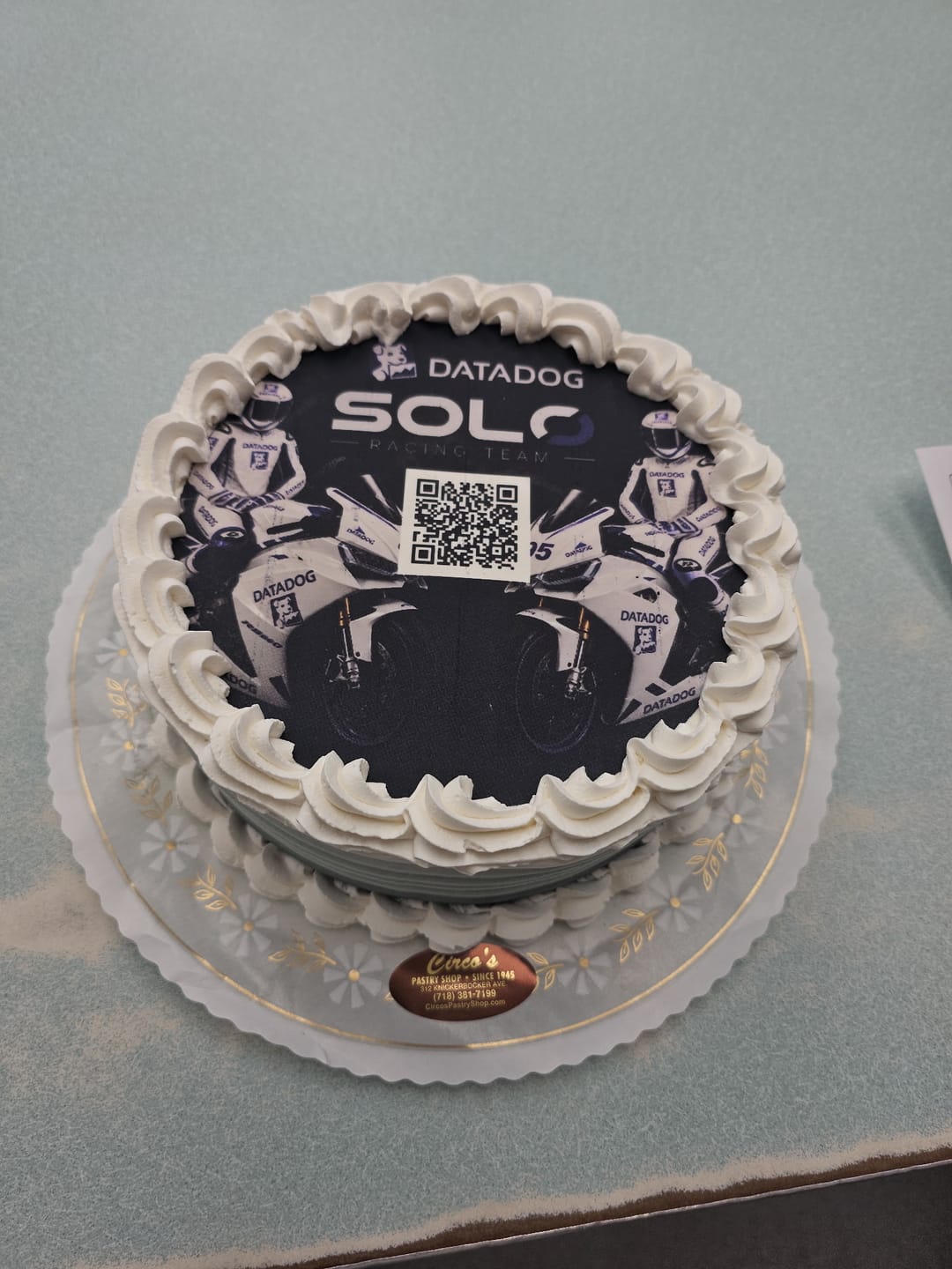 A dark printed cake with the Datadog logo