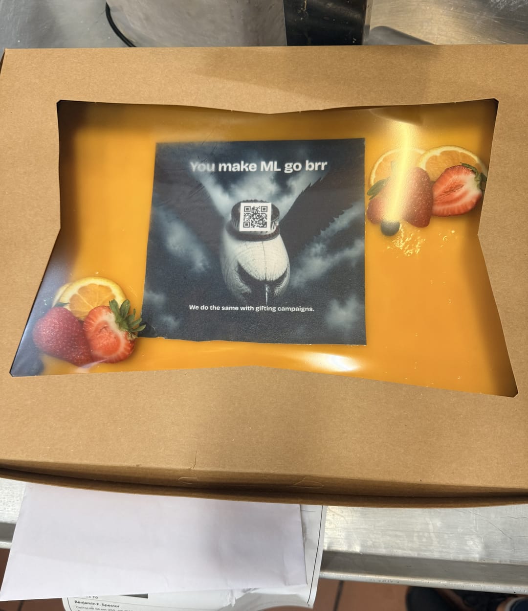 A boxed printed cake with a strawberry garnish