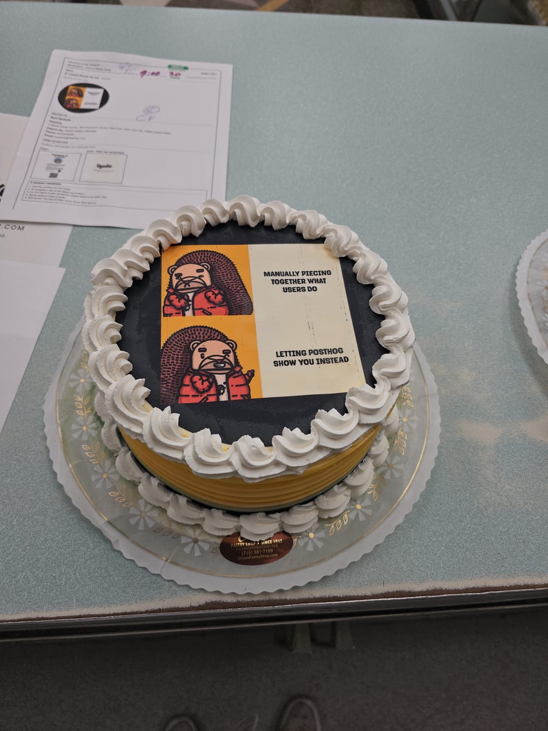 A second cake printed with the PostHog meme